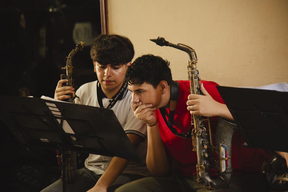 Zwei Saxophonisten beugen sich gemeinsam über ihre Noten